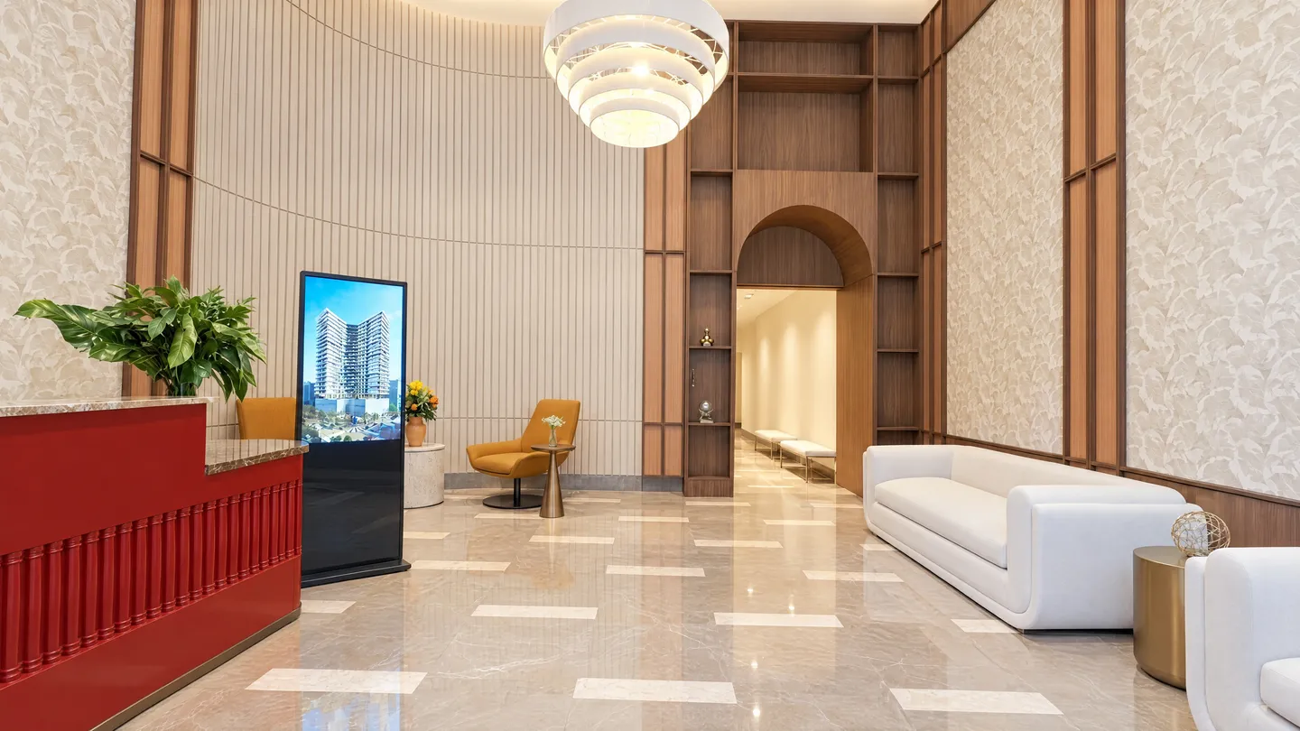 Lobby de doble altura con recepción, lámpara colgante y arco de madera hacia el pasillo