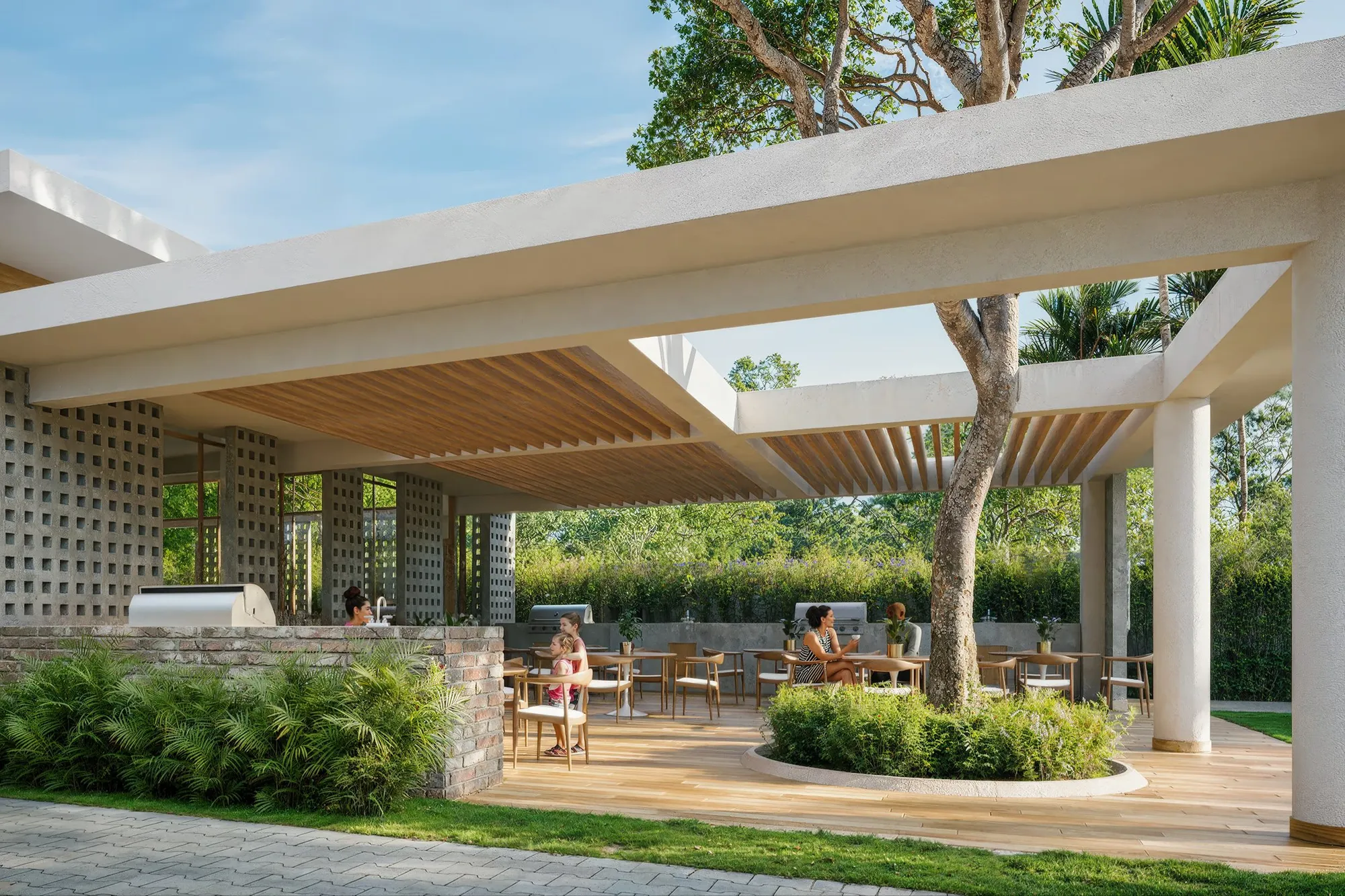 Terraza de la casa club de Brisas 6 con pérgola, mesas y área de BBQ